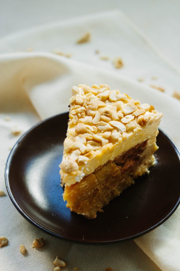 a slice of cake with pine nuts on top
