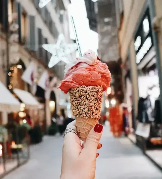 A cone of pink ice cream or gelato in an Italian street