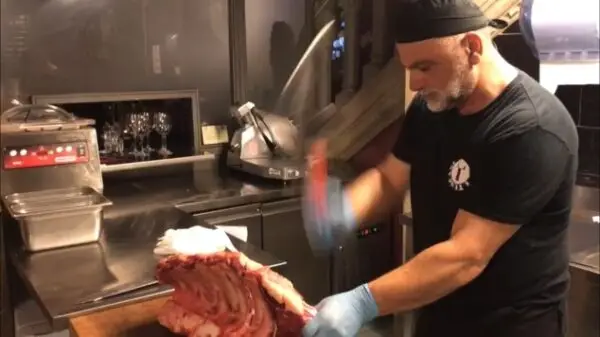 chef chops from a rack of steak